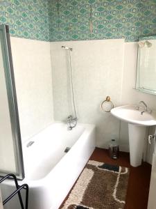 łazienka z wanną i umywalką w obiekcie Maison de 7 chambres avec vue sur le lac jardin clos et wifi a Le Dezert w mieście Montmartin-en-Graignes