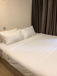 ein großes Bett mit weißer Bettwäsche und Kissen in der Unterkunft CR.HOTEL in Makkasan