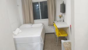 une petite chambre avec un lit et un bureau dans l'établissement 104 Apart mobiliado vista mar Praia de Iracema, à Fortaleza