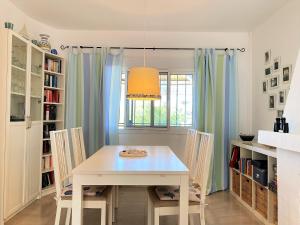 une salle à manger avec une table et des chaises blanches dans l'établissement Casa Almijara Casasol, à Nerja