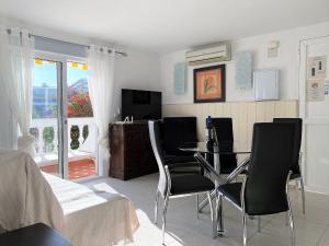 a living room with a dining room table and chairs at Apartamento Perlamar Burriana Casasol in Nerja