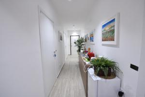um corredor com paredes brancas e um frigorífico branco em Karol Airport Bari em Bari Palese
