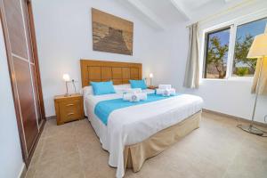 una camera da letto con un letto grande con cuscini blu di Villa Ambient / Sa Finqueta a Playa de Muro Altre 38 foto