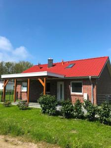 una casa in mattoni con tetto rosso su un cortile di Haus Carpe Diem a Schweiburg