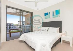 a bedroom with a large bed and a balcony at NEW - ZEN AT THE WATERFRONT - Luxury Waterfront Holiday Home for Families & Friends in Darwin