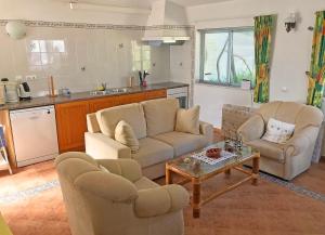 een woonkamer met twee banken en een tafel bij BUGANVÍLEA - Vivenda johanna in Lagos