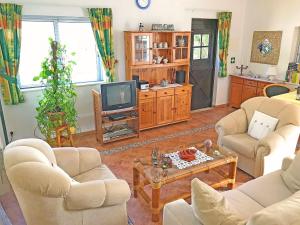 een woonkamer met twee banken en een tv bij BUGANVÍLEA - Vivenda johanna in Lagos