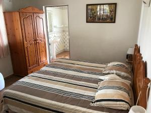 een bed in een slaapkamer met een houten frame bij BUGANVÍLEA - Vivenda johanna in Lagos +20 foto's