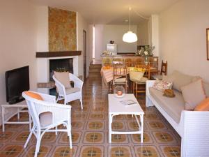 un soggiorno con divano, sedie e camino di Casa adosada en Playa de Pals by Apartaments Golf a Pals