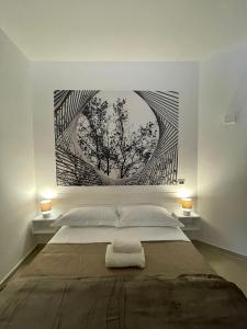een slaapkamer met een bed met een schilderij aan de muur bij Casa Nicola Maria in Grottaglie