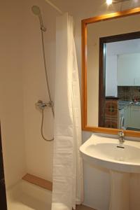 a bathroom with a shower and a sink and a mirror at Casa adosada en Playa de Pals by Apartaments Golf in Pals