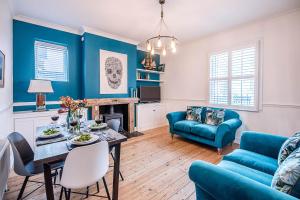 een woonkamer met blauwe muren en een tafel en stoelen bij 232a High Street Aldeburgh Air Manage Suffolk in Aldeburgh