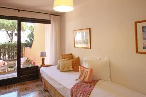 a bedroom with a bed with pillows and a window at Casa adosada en Playa de Pals by Apartaments Golf in Pals