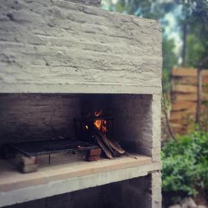 un horno de ladrillo con un fuego dentro de él en No Estamos Locos en Piriápolis