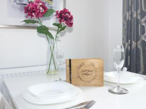 een tafel met borden en een vaas met bloemen en een doos bij Salt Yard Cottage No 2 in Whitstable