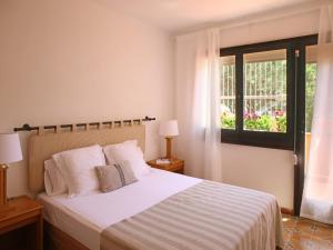 1 dormitorio con 1 cama con sábanas blancas y ventana en Casa adosada en Platja de Pals by Apartaments Golf, en Pals
