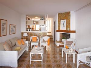 ein Wohnzimmer mit einem Sofa, Stühlen und einem Kamin in der Unterkunft Casa adosada en Platja de Pals by Apartaments Golf in Pals