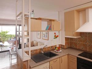 a kitchen with wooden cabinets and a sink and a window at Casa adosada en Platja de Pals by Apartaments Golf in Pals