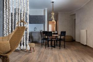 a living room with a table and chairs and a kitchen at Macrame Luxury Suites in Tríkala