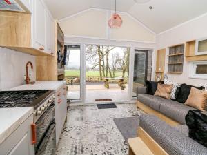 een keuken en een woonkamer met een bank bij Woodland Escape in Rhayader