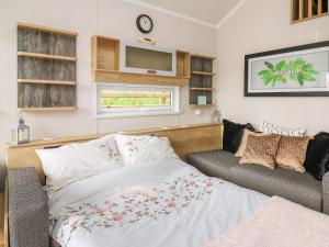una camera con letto, divano e TV di Woodland Escape a Rhayader