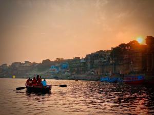 Un gruppo di persone in una barca sull'acqua di Live Free Hostel Varanasi a Varanasi