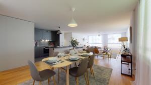 a dining room and living room with a table and chairs at Superbe modern apartment in city center in La Chaux-de-Fonds