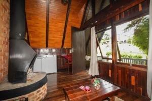 una sala de estar con una gran chimenea en una casa en Hotel Fazenda Floresta Negra, en Monte Verde