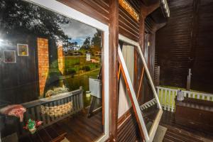 a window on the side of a house with a painting at Hotel Fazenda Floresta Negra in Monte Verde