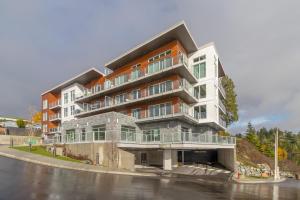 um grande edifício de apartamentos com varandas numa rua em Coffee With A View, Brand New One Bedroom At Sooke Harbour em Sooke