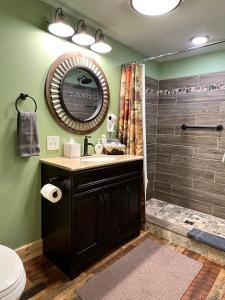 a bathroom with a sink and a shower with a mirror at Moosewood Inn in Saint Ignace