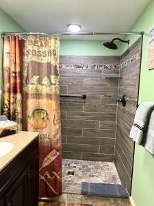 a bathroom with a shower with a shower curtain at Moosewood Inn in Saint Ignace