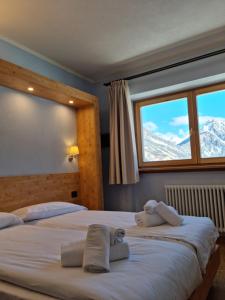 2 camas en una habitación de hotel con montañas nevadas en Hotel San Carlo, tra Bormio e Livigno, en Valdidentro