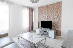 a living room with a tv and a coffee table at Suite Art Deco Near Disneyland Paris in Chessy