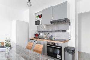 a kitchen with white cabinets and a stove top oven at Suite Art Deco Near Disneyland Paris in Chessy