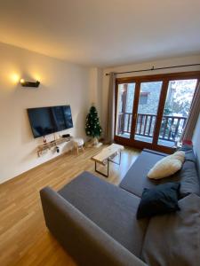 a living room with a couch and a large window at NÓRDIKA - Appartement chaleureux 10' des pistes in El Tarter