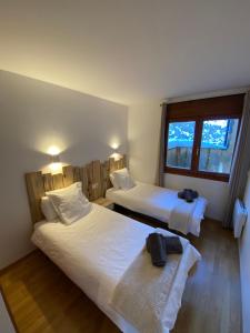 a bedroom with two beds and a window at NÓRDIKA - Appartement chaleureux 10' des pistes in El Tarter