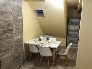 普利比利那的住宿－Apartmány Matilda，一间配备有白色桌椅的用餐室