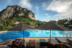 a resort pool with a mountain in the background at Peace Laguna Resort & Spa - SHA Extra Plus in Ao Nang Beach