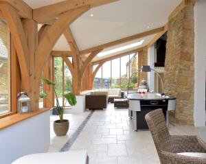 a living room with wooden beams and a table and chairs at The Little Stable at Flos Cottages in West Coker