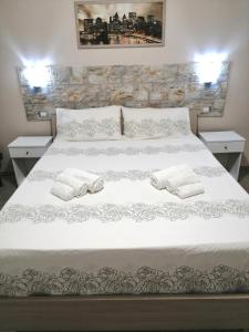 Una cama blanca con dos toallas blancas. en Casa Vacanza Al Massimo, en Palermo