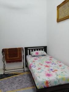 關丹的住宿－HOMESTAY KUANTAN INDERA SEMPURNA 2，卧室配有一张床,墙上挂着一幅画