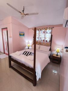 um quarto com uma cama e uma ventoinha de tecto em Maria Paulo Guest House Bar and Restaurant em Agonda