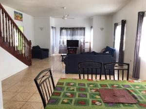 a living room with a table and chairs and a couch at Beautiful 2-Bed Apartment in sunny Jamaica in Silver Sands