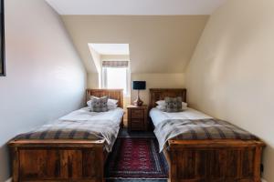 two twin beds in a room with a window at Luxury Inverness central apartment private parking in Inverness