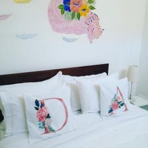 Una cama con almohadas blancas con flores. en La Palma, en Viña del Mar