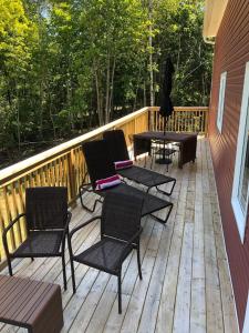 a wooden deck with chairs and tables on it at The New Brunswick Bed and Breakfast in Saint Andrews