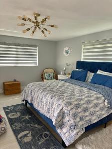 een slaapkamer met een blauw bed en een plafondventilator bij Punta Gorda Isles Haven in Punta Gorda