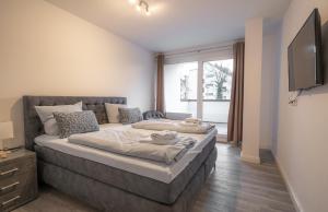a bedroom with a large bed and a television at My Apartment im Bremer Viertel in Bremen