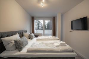 two beds in a room with a flat screen tv at My Apartment im Bremer Viertel in Bremen